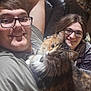 Lorelai joined the competition — help win amazing prizes! person, smiling, glasses, cat, indoor, couch, furniture, fluffy_cat, brown_cat, happy, cozy, relaxed, portrait, casual, home, seated, pet, friendship, leisure, comfort