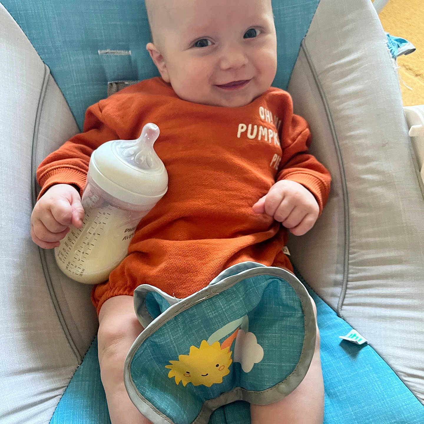 Theodore is registered to the contest to win money with this photo: baby, beverage, bodypart, bottle, clothing, couch, cushion, face, finger, furniture, happy, head, homedecor, milk, person, photography, portrait, shaker, sitting, t_shirt