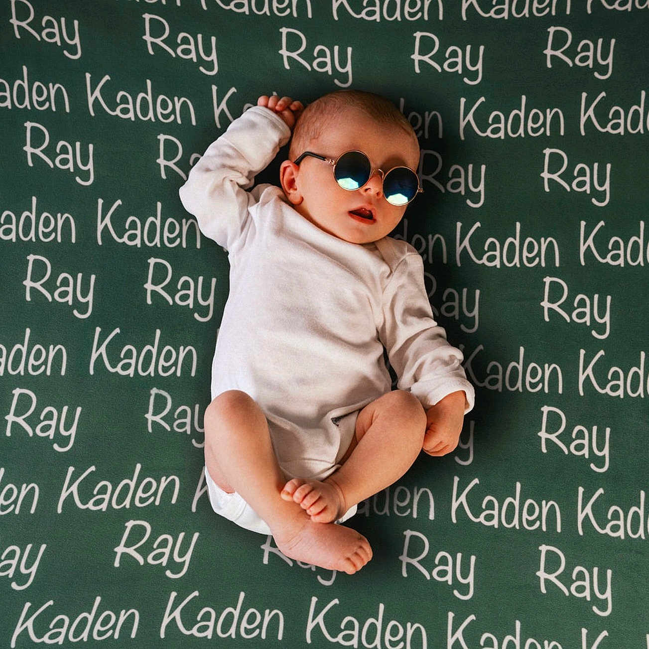 Kaden joined the competition — help win amazing prizes! baby, child, infant, sunglasses, white_onesie, blanket, text, names, lying_down, cute, cool, relaxed, foot, hand, head, skin, person, indoor, portrait, fashion
