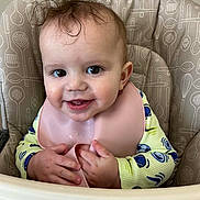 Gabriel joined the competition — help win amazing prizes! baby, high_chair, bib, smile, happy, toddler, child, food, messy, clothing, face, hands, indoor, pattern, yellow, pink, cute, portrait, feeding, young_child