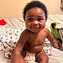 baby, child, smile, diaper, bed, blanket, indoor, person, cute, happy, skin, curly_hair, infant, sitting, young, cheeks, playful, room, comfort, joy