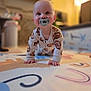 Maeve is registered to the contest to win money with this photo: baby, pacifier, crawling, play_mat, pajamas, indoor, child, infant, floor, hands, head, cute, smiling, young_child, person, home, soft_lighting, background_blur, face, eyes