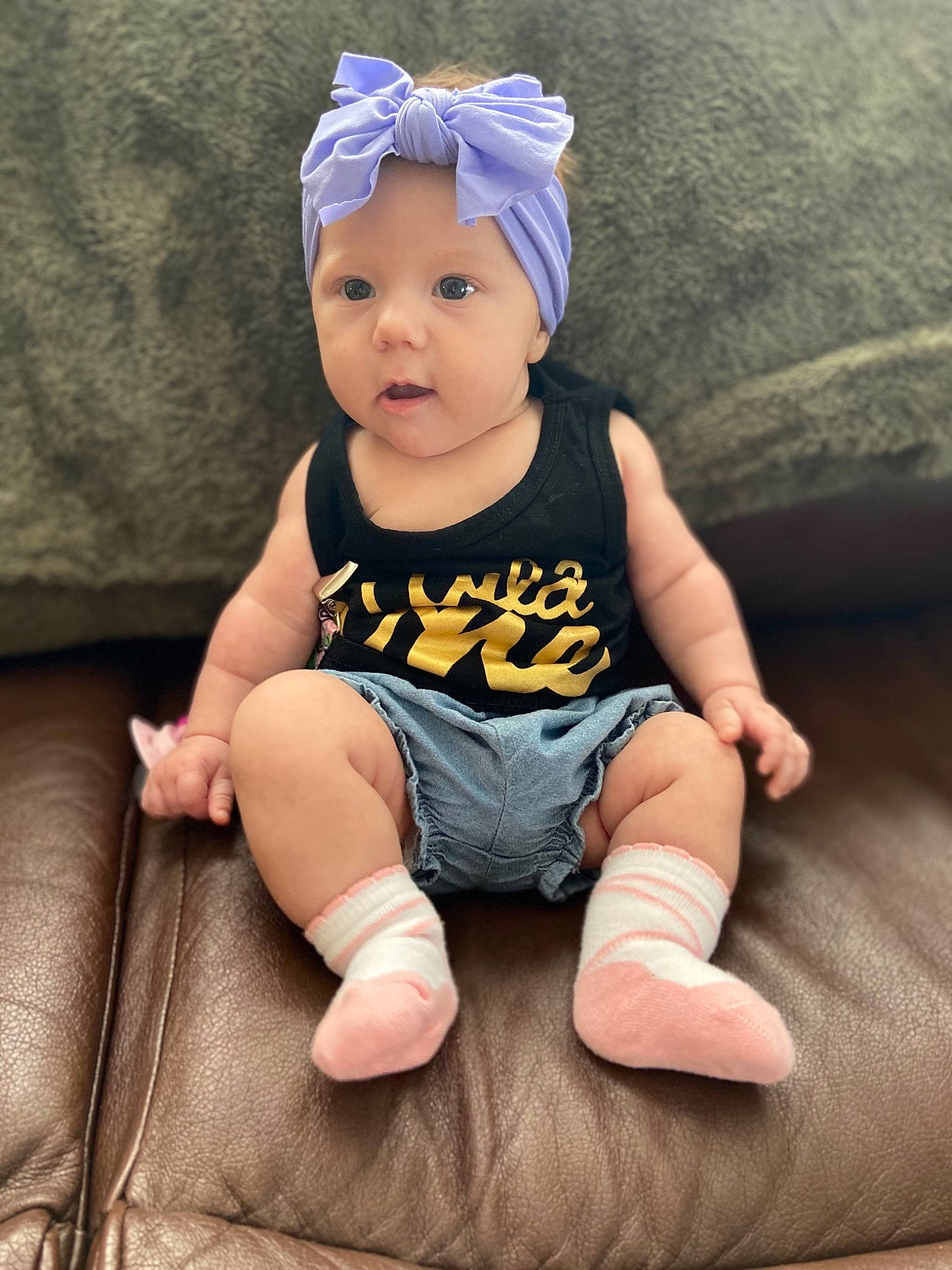 Vivian is registered to the contest to win money with this photo: baby, baby_toddler_clothing, cap, cheek, chin, comfort, costume_hat, eye, foot, happy, head, headpiece, headwear, human_leg, iris, pattern, person, sleeve, t_shirt, thigh