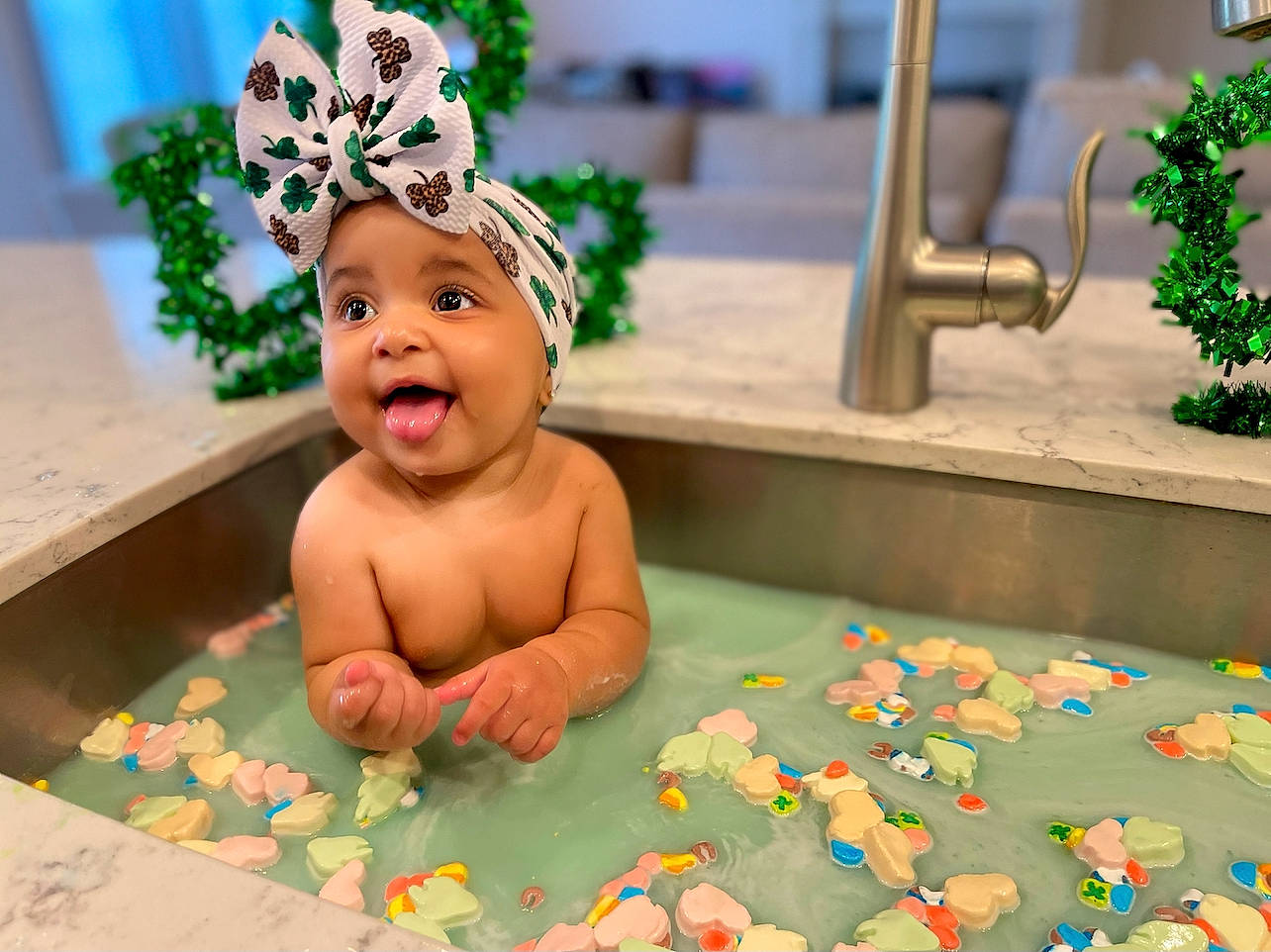 Lillie is registered to the contest to win money with this photo: adaptation, baby, baby_toys, blue, cap, child, crown, event, flooring, fun, green, happy, headpiece, headwear, leisure, person, plant, room, smile, toddler