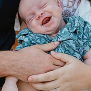 Christopher is registered to the contest to win money with this photo: baby, smiling, happy, child, hands, holding, clothing, patterned_shirt, adult, love, closeup, portrait, infant, family, skin, lace, jeans, person, outdoor, tenderness