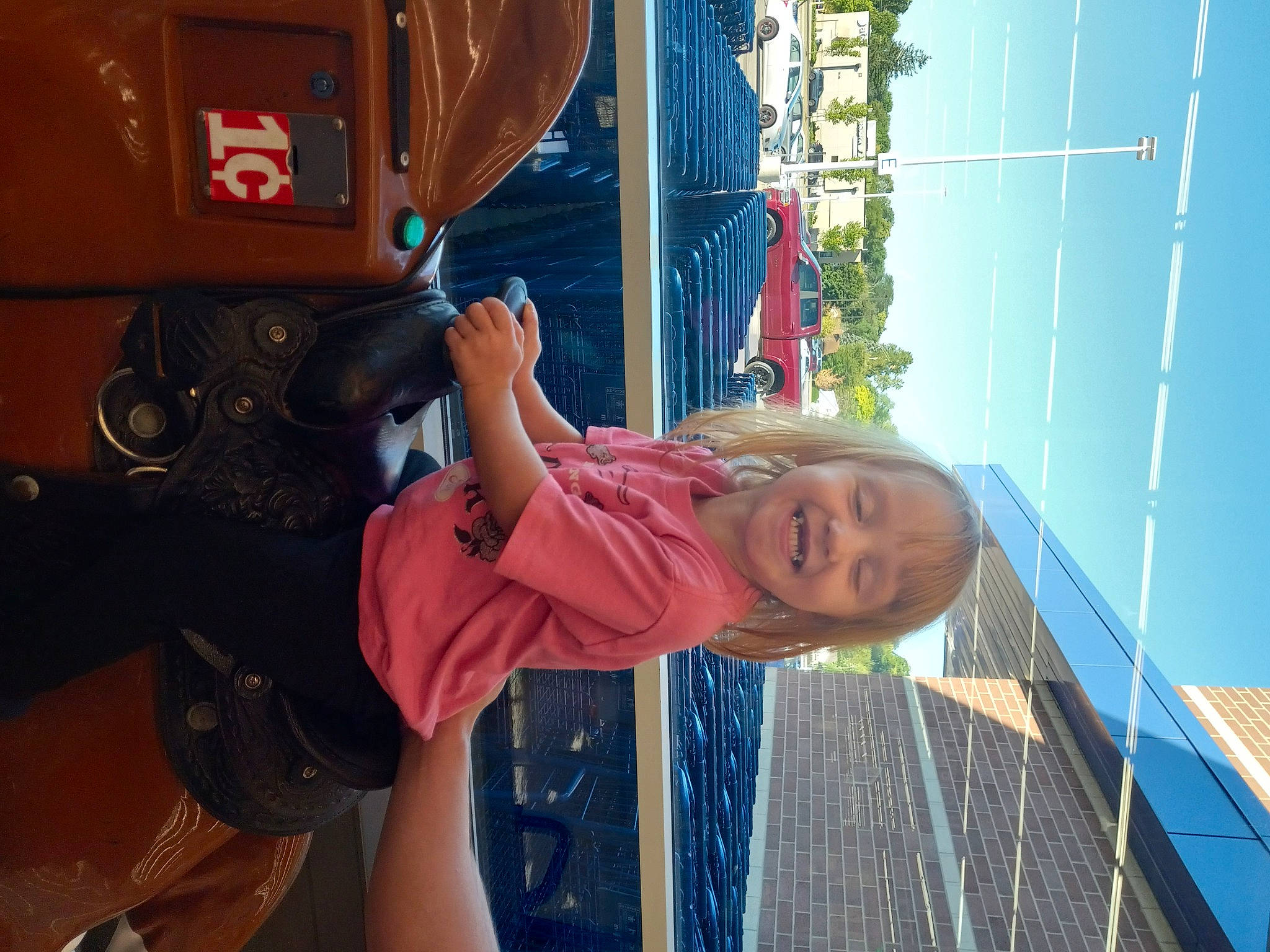 Maelynn is registered to the contest to win money with this photo: automotive_exterior, automotive_tire, automotive_wheel_system, bumper, city, electric_blue, fun, happy, joy, leisure, machine, motor_vehicle, outdoor_play_equipment, person, recreation, sky, smile, tire, toddler, travel