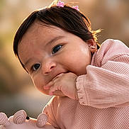 Layla is registered to the contest to win money with this photo: baby, blurry_background, chewing, child, close_up, cute, earrings, girl, hair_clips, hand, happy, infant, outdoor, pink_clothing, portrait, smiling, soft_toy, toy, warm_light, young