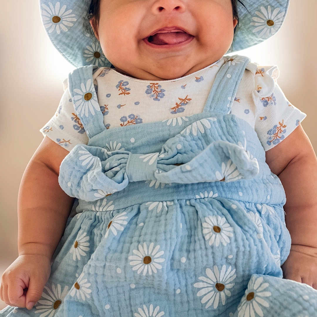 Layla joined the competition — help win amazing prizes! baby, child, smiling, hat, blue_clothing, daisy_pattern, cute, portrait, happy, infant, person, fashion, apparel, childhood, cute_outfit, closeup, adorable, young_child, face, sitting