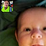 baby, infant, child, video_call, adult, face, portrait, smiling, indoor, blanket, close_up, head, eyes, nose, mouth, striped_clothing, smartphone, screen, portrait_mode, conversation