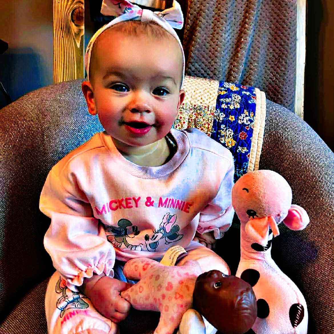 Spectacular is registered to the contest to win money with this photo: baby, chair, child, clothing, cozy, cute, happy, headband, homedecor, indoor, infant, mickey_minnie, person, pink, plush, portrait, sitting, smiling, stuffed_toy, toy