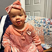 Spectacular joined the competition — help win amazing prizes! baby, pink_dress, headband, bow, quilt, seated, indoor, child, smile, cute, portrait, person, furniture, happy, cozy, colorful, clothing, footwear, hand, face