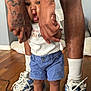 Noemi joined the competition — help win amazing prizes! toddler, child, baby, red_bow, blue_shorts, red_sandals, tattoo, adult, hand_holding, wooden_floor, sneakers, white_socks, indoor, person, legs, feet, casual_clothing, support, family, cute