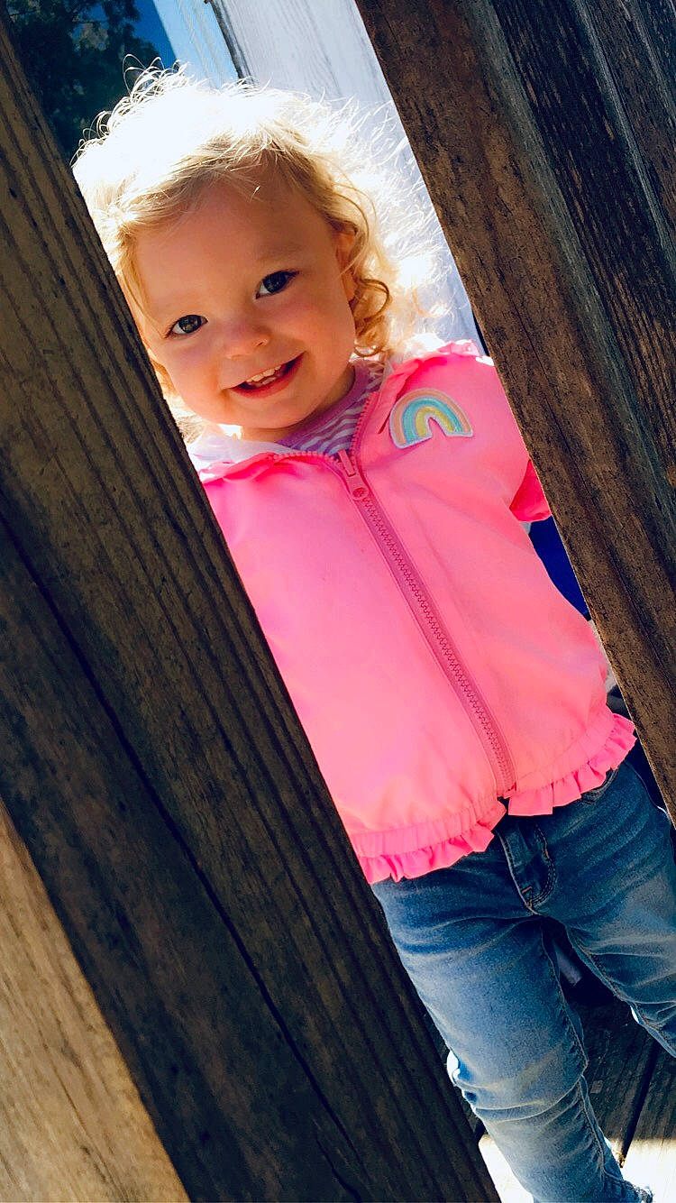 Johanna is registered to the contest to win money with this photo: beauty, blond, cheek, child, child_model, eye, jeans, joy, outerwear, person, photography, pink, skin, smile, standing, toddler, tree, wood