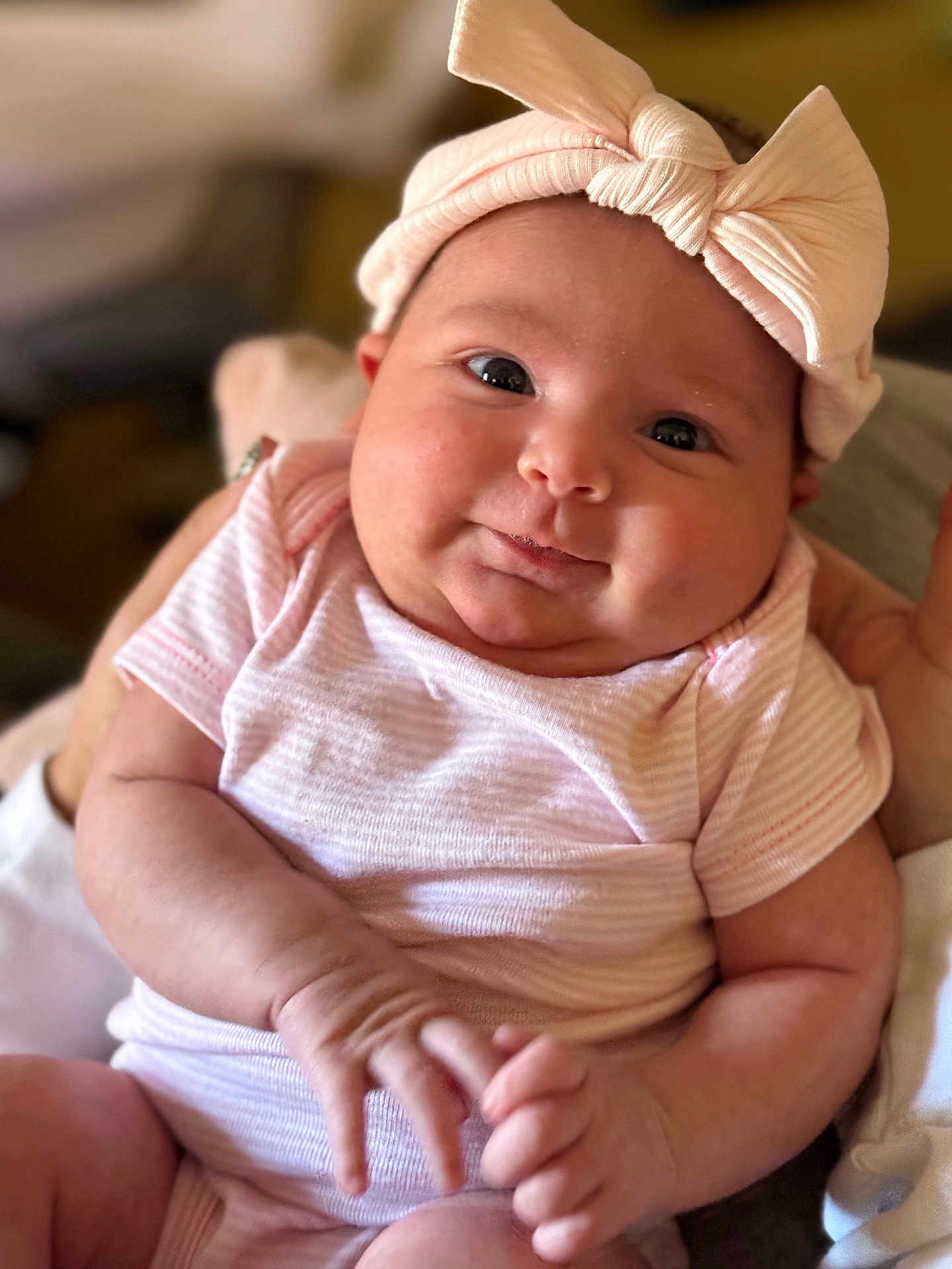 Chevelle is registered to the contest to win money with this photo: baby, infant, child, pink_bow, headband, onesie, cute, chubby_cheeks, portrait, hands, skin, smile, indoor, person, newborn, soft_focus, clothing, face, expression, baby_girl