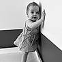 Lexie participe au concours pour gagner de l'argent avec cette photo : baby, barefoot, black_and_white, child, corner, curious, dress, expression, face, feet, hands, indoor, person, portrait, small, standing, striped, toddler, wall, young_child