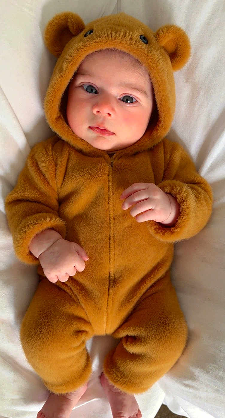 Musfirah is registered to the contest to win money with this photo: baby, infant, child, cute, fuzzy_suit, bear_costume, hood, ears, soft_texture, blanket, hands, feet, portrait, indoors, closeup, adorable, expression, sleepwear, warm, cozy