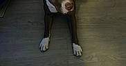 Papa is registered to the contest to win money with this photo: dog, brown_dog, white_markings, short_coat, pit_bull_type, standing, lying_down, stretching, indoor, wooden_floor, home, pet, animal, portrait, looking_at_camera, front_legs, white_paws, tail, dim_lighting, floor