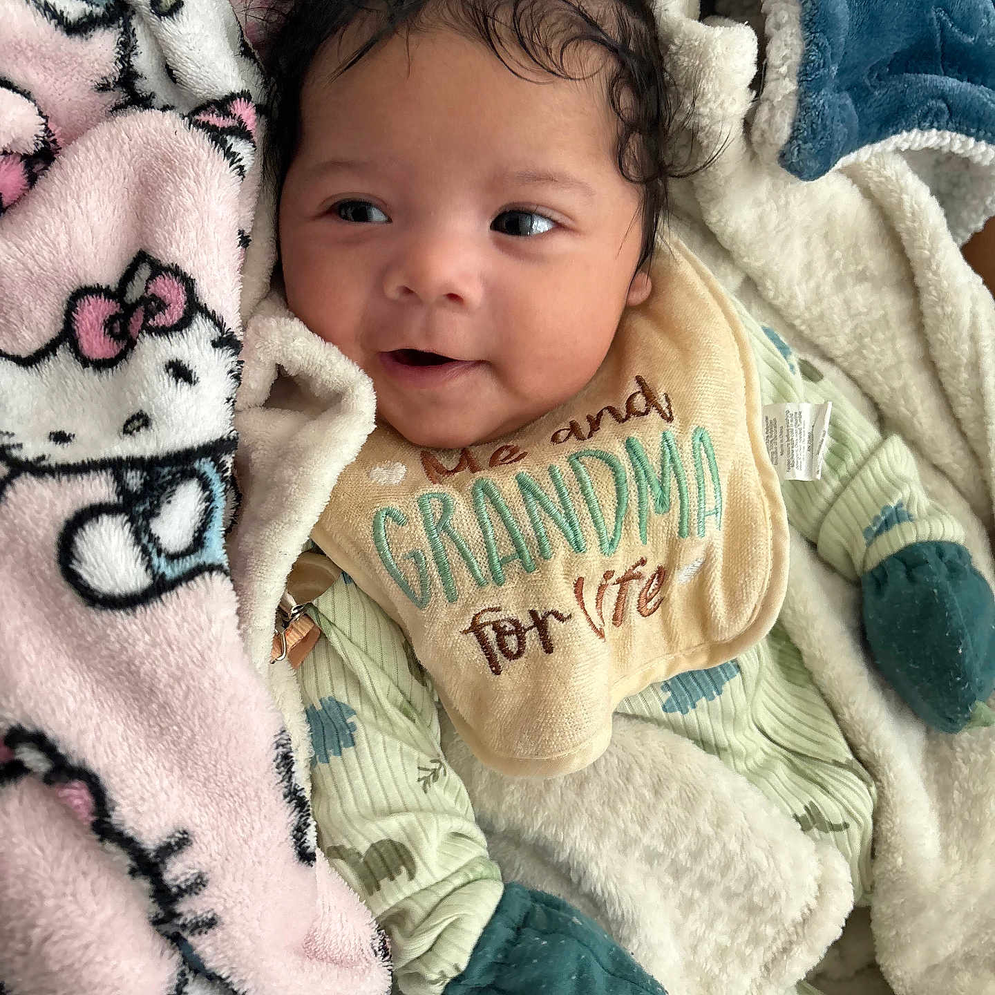 Eremias Hurd is registered to the contest to win money with this photo: baby, bib, blanket, child, clothing, comfort, cozy, cute, fabric, face, happy, indoor, infant, mittens, portrait, sleepwear, smiling, soft, toddler, warm