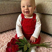 Cory-Grey joined the competition — help win amazing prizes! baby, infant, smiling, red_overalls, white_shirt, roses, bouquet, plush_rug, sitting, couch, living_room, portrait, indoor, happy, hands, socks, closeup, face, toddler, valentines