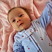 Aurora is registered to the contest to win money with this photo: baby, infant, blanket, blue_onesie, cherry_pattern, soft_texture, cute, lying_down, child, face, expression, skin, head, clothing, newborn, sleepwear, comfort, warm, indoor, portrait