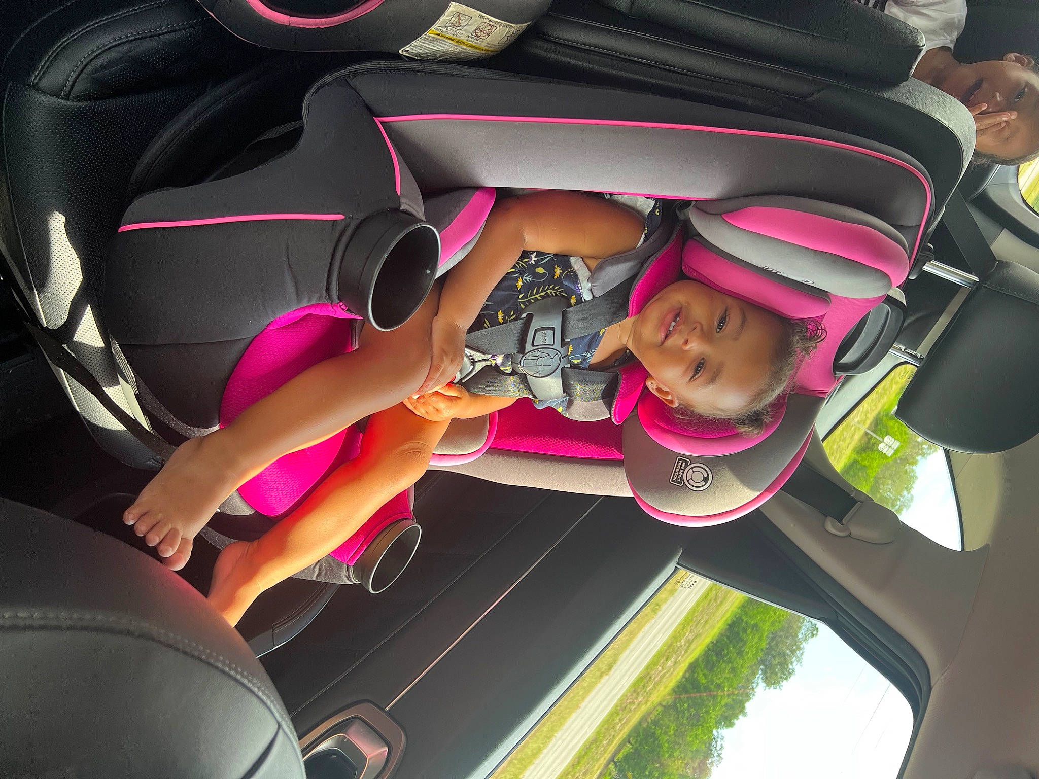 Cayleigh is registered to the contest to win money with this photo: auto_part, automotive_design, automotive_exterior, car, family_car, fun, hand, leisure, magenta, motor_vehicle, person, pink, plant, recreation, smile, steering_wheel, toddler, tree, vehicle, vehicle_door