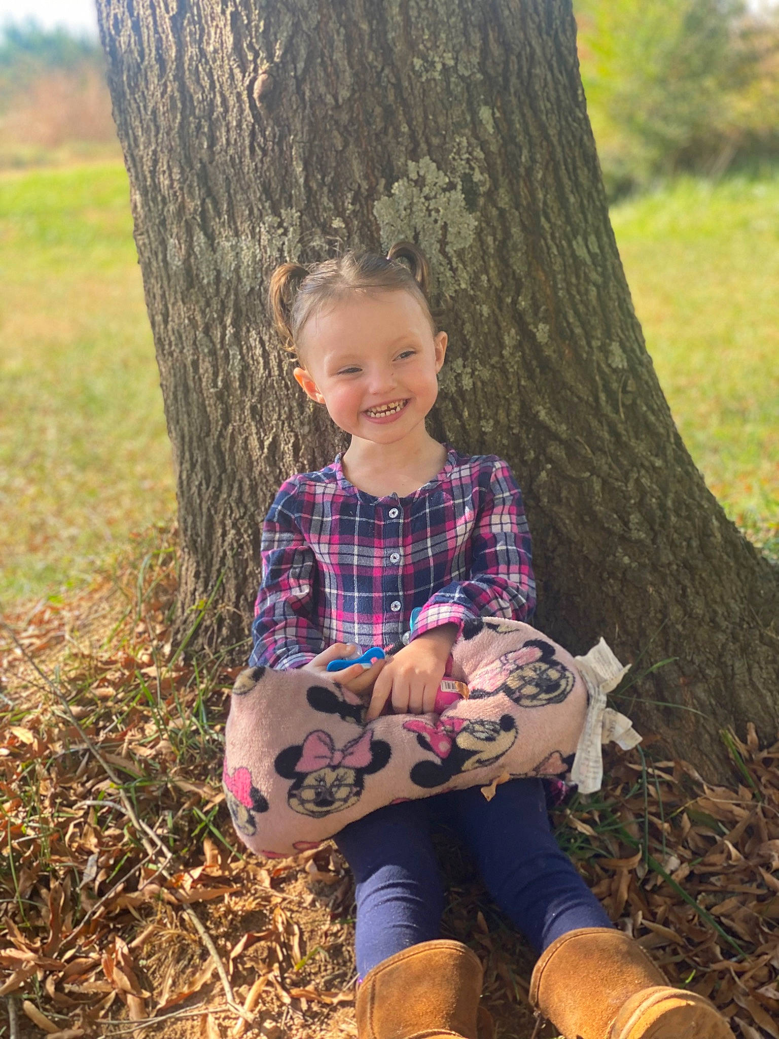 Rosalie is registered to the contest to win money with this photo: arm, fawn, forest, grass, hand, happy, joy, leaf, leg, people_in_nature, person, plaid, plant, shoe, smile, sock, t_shirt, tartan, tree, trunk