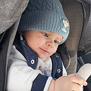 Mathis a rejoint le concours — aidez-le/la à gagner de superbes lots ! baby, child, blue_hat, knit_hat, lion_king, plush_toy, car_seat, blanket, coat, sweater, cute, infant, warm_clothing, hands, face, portrait, indoor, soft_toy, close_up, winter_wear