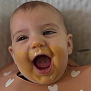 Lylou participe au concours pour gagner de l'argent avec cette photo : baby, bib, cheeks, closeup, clothing, cute, expression, eyes, face, feeding, food, happy, head, indoor, infant, messy, mouth_open, skin, smile, tongue