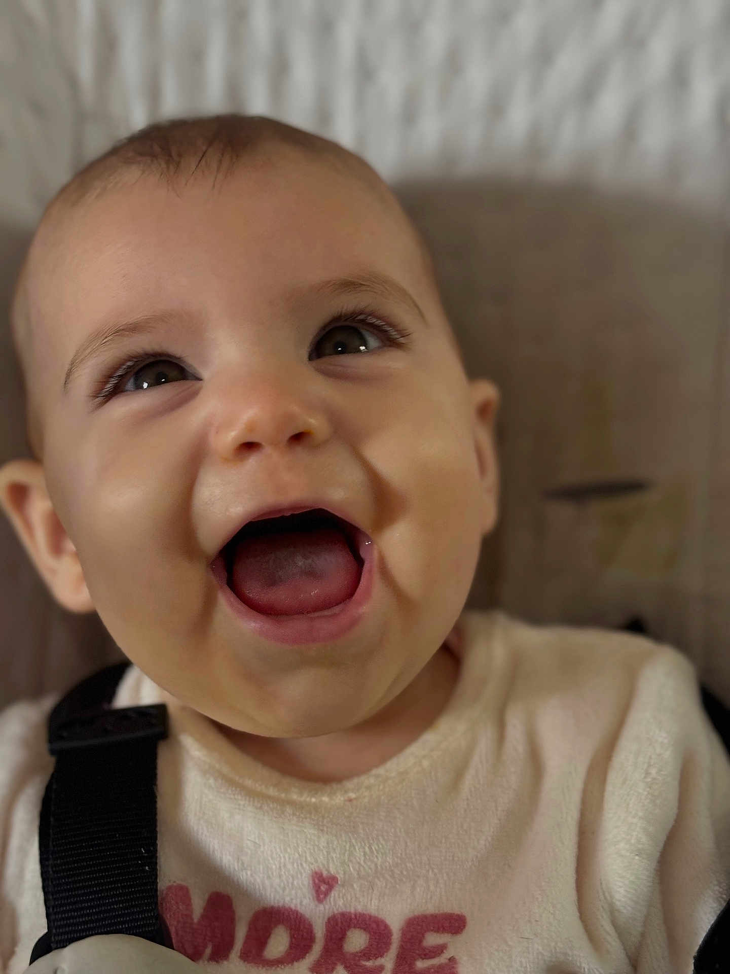 Lylou a rejoint le concours — aidez-le/la à gagner de superbes lots ! baby, smiling, closeup, face, eyes, mouth_open, infant, clothing, white_shirt, black_strap, happy, cute, skin, head, person, portrait, indoors, young_child, expression, babywear