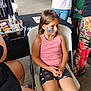 Bayleigh joined the competition — help win amazing prizes! child, girl, face_painting, chair, pink_tank_top, shorts, heart_pattern, table, face, people, indoor, casual_clothing, art_supplies, makeup_kit, waiting, sitting, legs, hands, brown_hair, expression