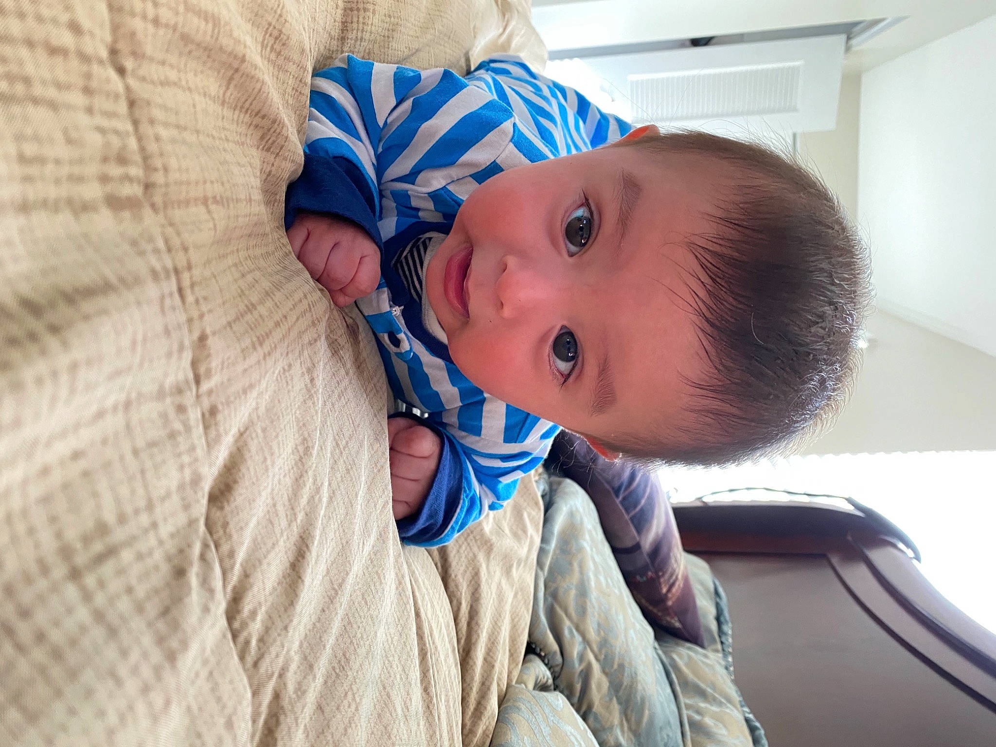 Dariel is registered to the contest to win money with this photo: baby, baby_safety, baby_toddler_clothing, cheek, child, comfort, electric_blue, fun, happy, iris, linens, nose, pattern, person, room, sitting, sleeve, surprise, toddler