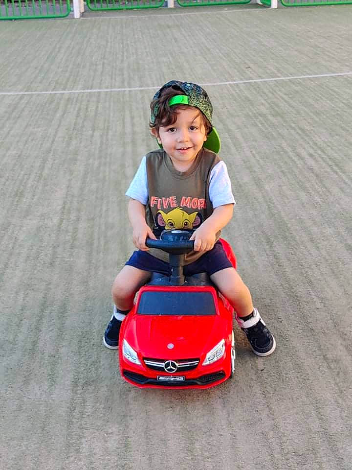Jessim participe au concours pour gagner de l'argent avec cette photo : automotive_design, automotive_exterior, automotive_wheel_system, baby, bumper, car, green, happy, head, headwear, helmet, joy, land_vehicle, motor_vehicle, person, riding_toy, smile, tire, toddler, toy