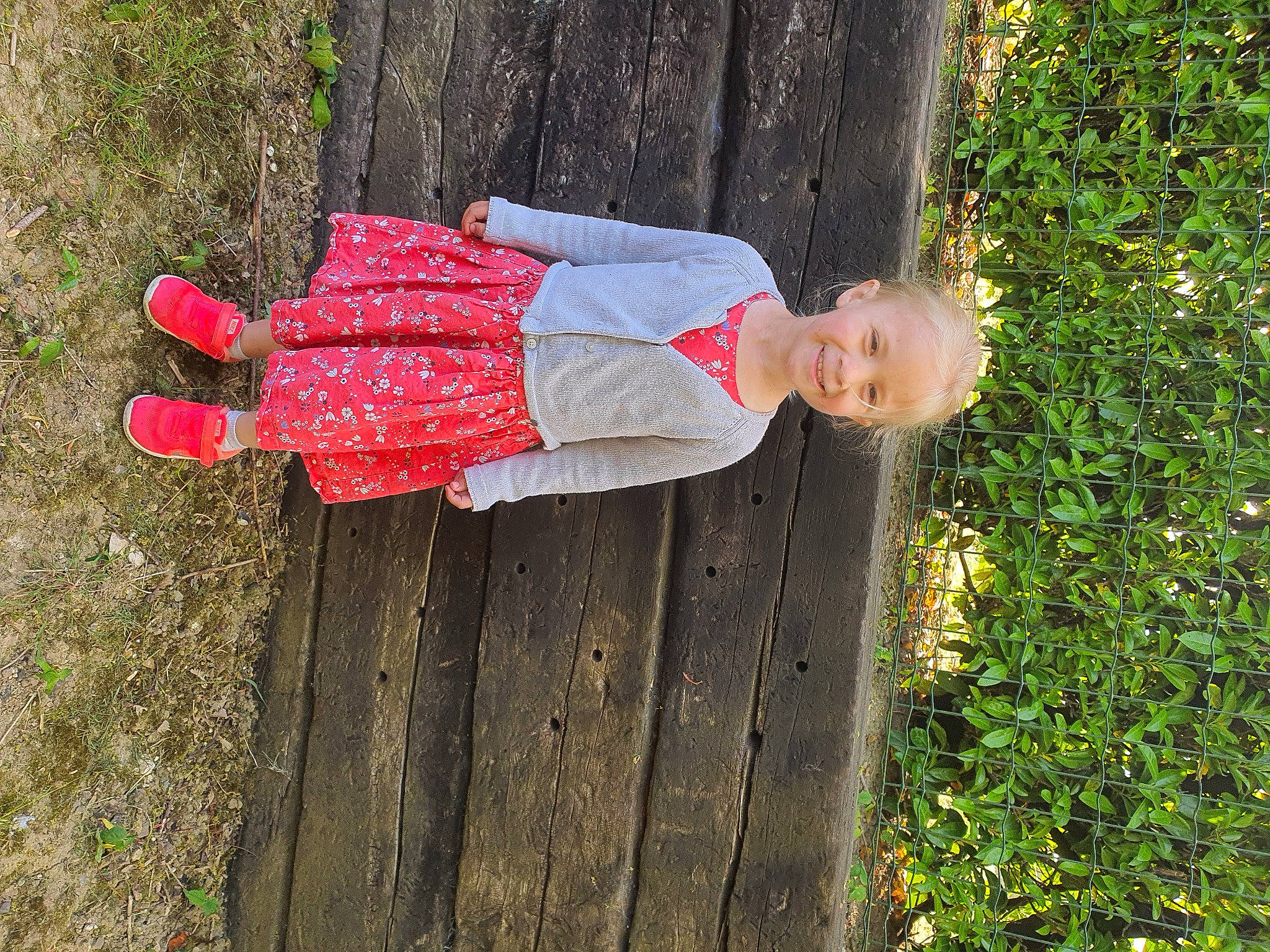 Elyna a rejoint le concours — aidez-le/la à gagner de superbes lots ! baby_toddler_clothing, carmine, child, fun, grass, groundcover, happy, human_leg, joy, leisure, magenta, pattern, people_in_nature, person, plant, shrub, smile, toddler, tree, trunk