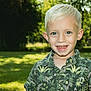 background, blond_hair, blue_eyes, boy, casual_clothing, child, daylight, face, grass, greenery, happy, nature, outdoor, person, portrait, short_sleeve_shirt, smiling, sunlight, trees, young
