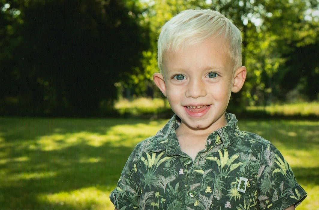 Kélyan a rejoint le concours — aidez-le/la à gagner de superbes lots ! child, boy, smiling, outdoor, greenery, grass, trees, blond_hair, short_sleeve_shirt, portrait, happy, nature, sunlight, casual_clothing, young, person, daylight, face, blue_eyes, background