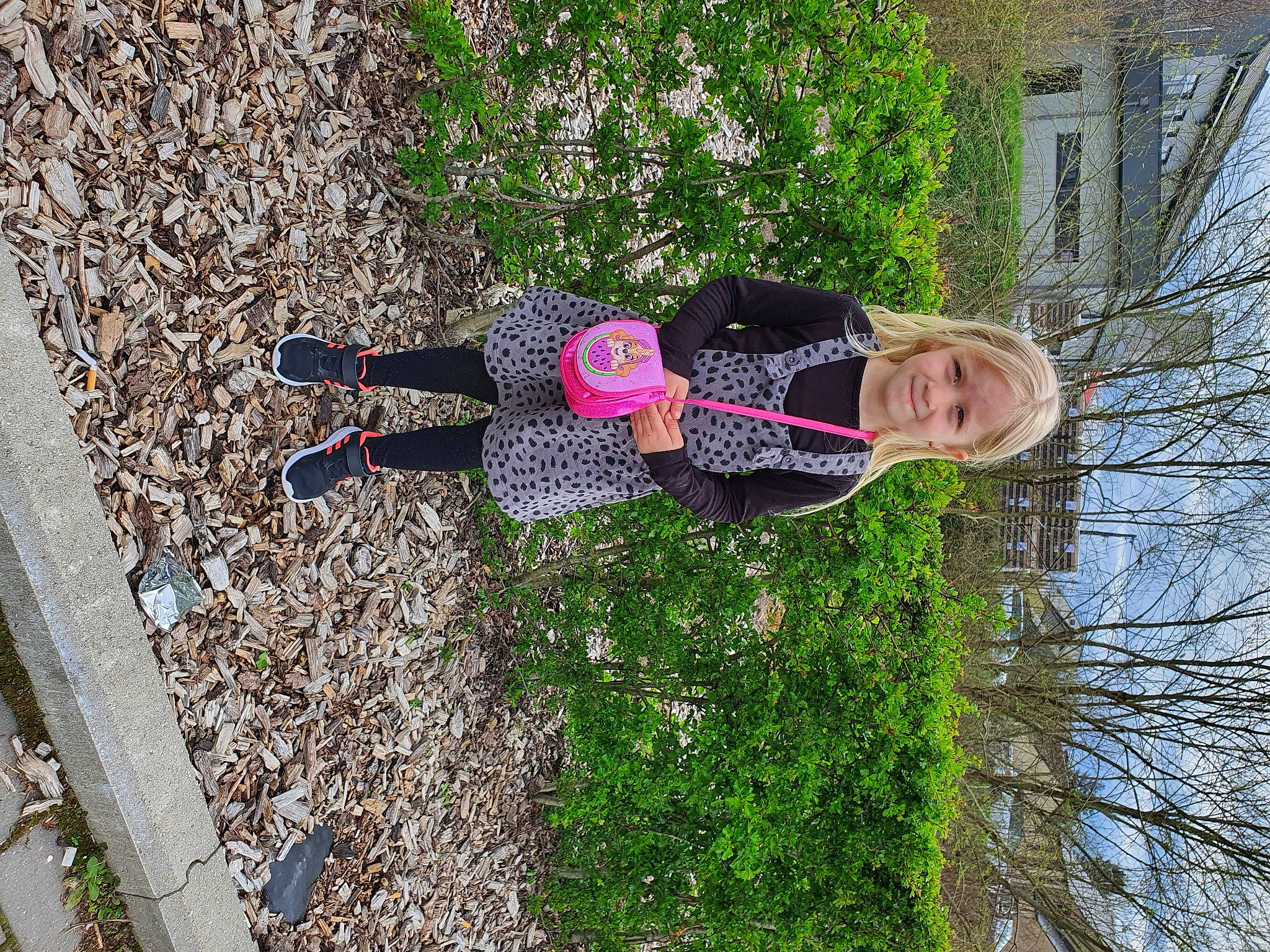 Elyna a rejoint le concours — aidez-le/la à gagner de superbes lots ! building, grass, groundcover, joy, people_in_nature, person, plant, shadow, shrub, smile, tree, walking_shoe, window