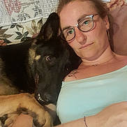 Stitch a rejoint le concours — aidez-le/la à gagner de superbes lots ! woman, dog, german_shepherd, glasses, couch, floral_pattern, tattoo, bracelet, relaxing, indoor, close_up, affection, pet, companion, portrait, casual_clothing, resting, human_animal_bond, head, face