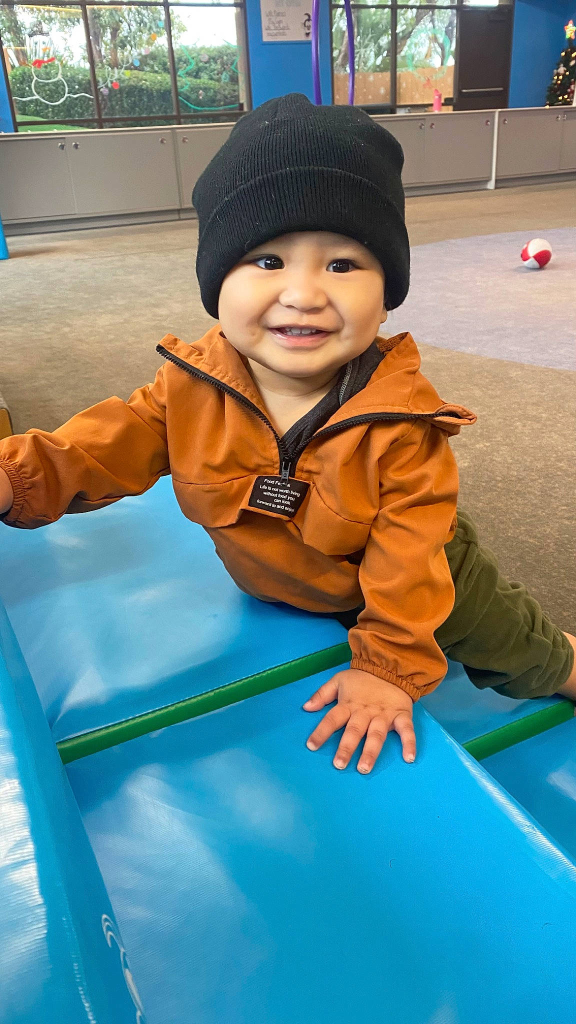 Kenai joined the competition — help win amazing prizes! baby, baby_toddler_clothing, cap, child, electric_blue, fun, grass, happy, headwear, joy, knit_cap, leisure, outdoor_play_equipment, person, photograph, play, playground, recreation, sitting, smile