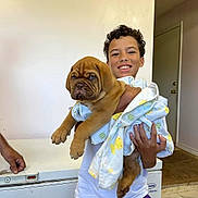 Leonard joined the competition — help win amazing prizes! boy, puppy, dog, child, blanket, indoor, smile, curly_hair, white_shirt, purple_shorts, door, floor, wall, hand, appliance, wrinkled_dog, cute, holding, happy, portrait