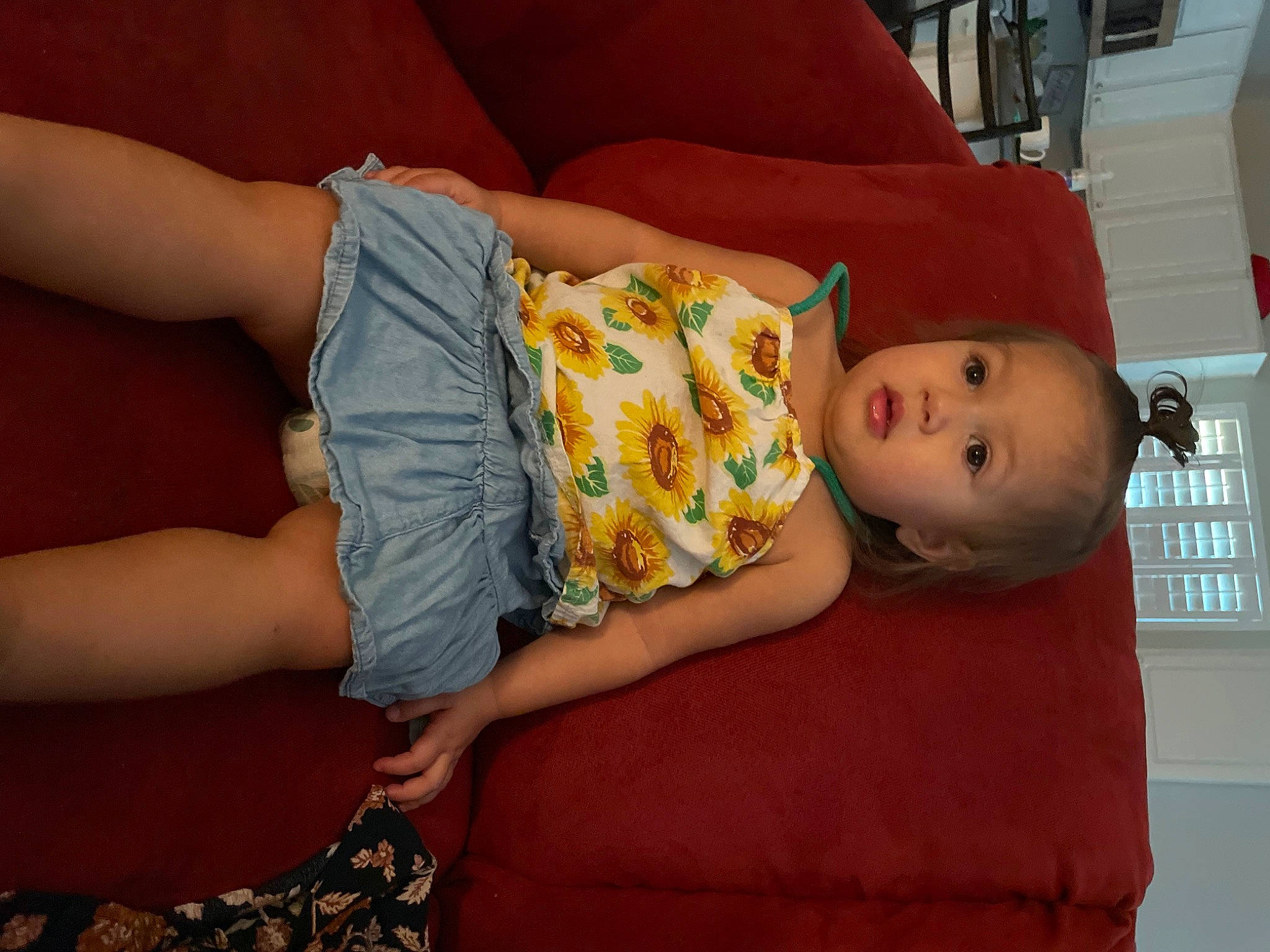 Oaklee is registered to the contest to win money with this photo: baby, baby_toddler_clothing, cheek, child, comfort, couch, flooring, fun, hat, human_leg, joint, knee, lap, pattern, person, room, sitting, skin, surprise, thigh