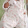 newborn, baby, sleeping, onesie, mittens, blanket, floral_pattern, infant, cute, peaceful, resting, soft_lighting, indoors, portrait, clothing, child, face, head, skin, young