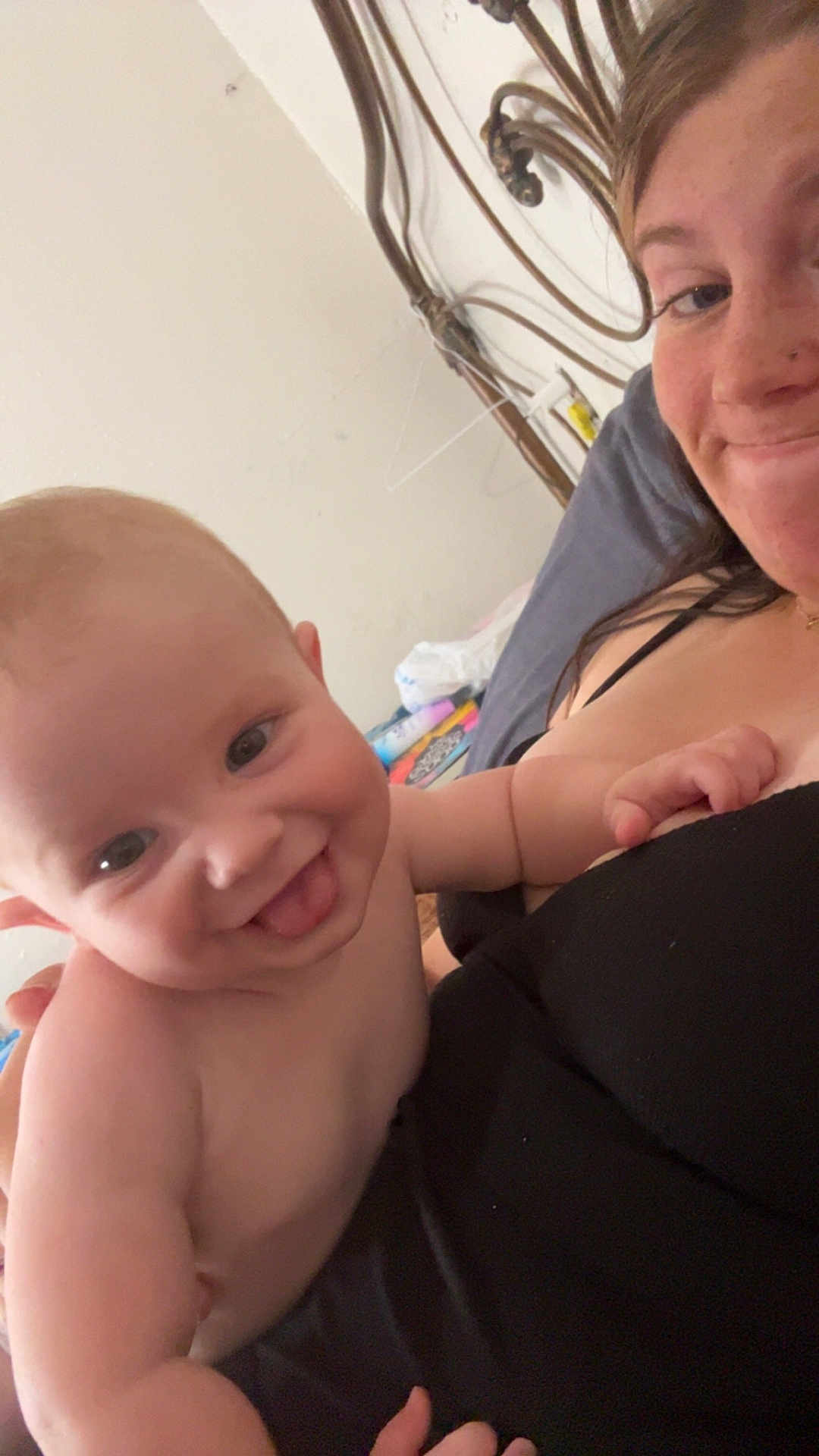 Abraham is registered to the contest to win money with this photo: baby, child, woman, smiling, tongue_out, indoor, bed, blanket, person, face, skin, hair, happy, holding, casual_clothing, furniture, head, comfort, cozy, portrait
