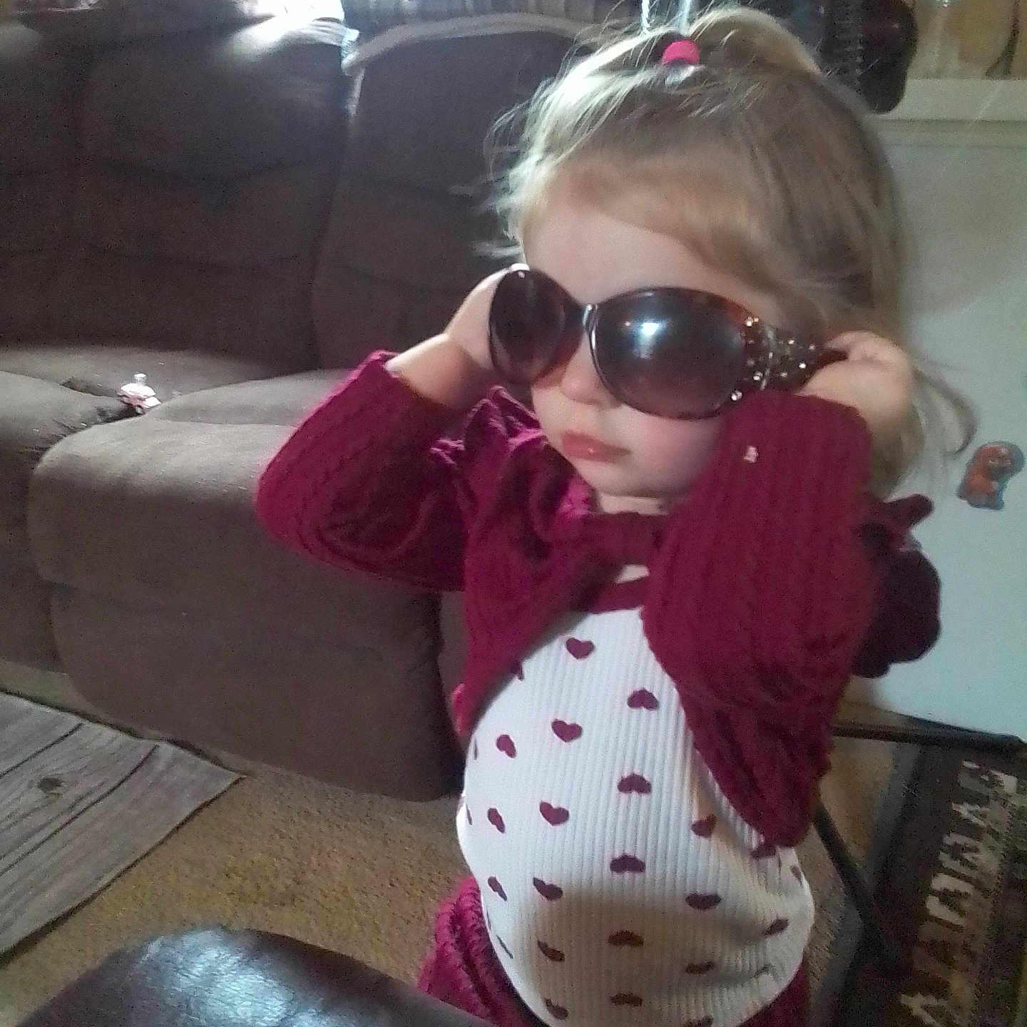 Kaydence joined the competition — help win amazing prizes! carpet, child, clothing, cute, fan, fashion, furniture, girl, glasses, hair, heart, home, indoor, living_room, pattern, person, sofa, sunglasses, sweater, toy