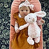 Michelle joined the competition — help win amazing prizes! baby, child, infant, portrait, sitting, pink_chair, stuffed_animal, bunny, plush_toy, headband, bow, mustard_dress, smiling, face, indoor, carpet, patterned_rug, cushioned_seat, fashion, adorable