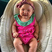 Michelle joined the competition — help win amazing prizes! baby, infant, child, smiling, portrait, seated, bouncer, baby_seat, pink_outfit, green_collar, bow_headband, watermelon_pattern, bare_feet, indoors, happy, cute, face, playful, closeup, photography