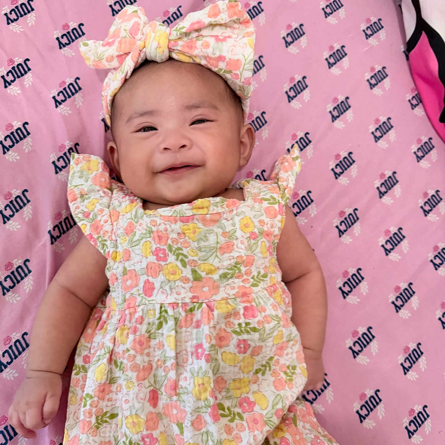 Princess joined the competition — help win amazing prizes! baby, infant, smiling, floral_dress, headband, pink_blanket, juicy_logo, cute, lying_down, happy, child, portrait, apparel, patterned_clothing, one_person, indoors, closeup, skin, baby_girl, small_child