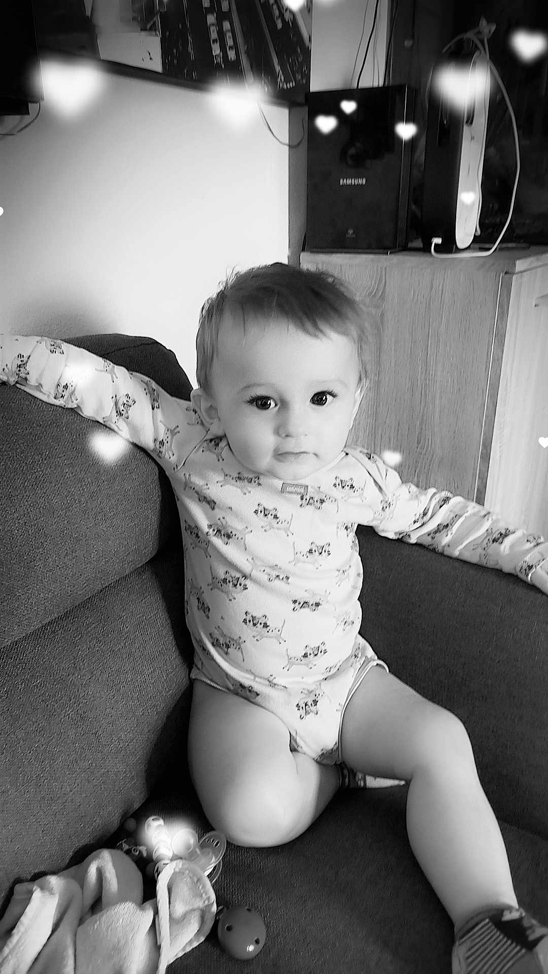 Eden Sigler participe au concours pour gagner de l'argent avec cette photo : arm, baby, black_and_white, blanket, child, clothing, couch, cute, eyes, face, hair, heart_shape, indoors, infant, legs, long_sleeve, pacifier, relaxing, sofa, toy