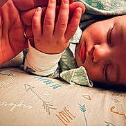 Eli joined the competition — help win amazing prizes! baby, sleeping, hand, pillow, pattern, arrows, love, dance, closeup, infant, peaceful, resting, soft_focus, skin, clothing, toddler, adult_hand, nap, cute, warm_lighting
