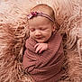 baby, newborn, infant, swaddled, wrapped, blanket, fur, headband, smile, peaceful, portrait, studio, soft_texture, cozy, pink, rose, face, hand, eyes_closed, skin