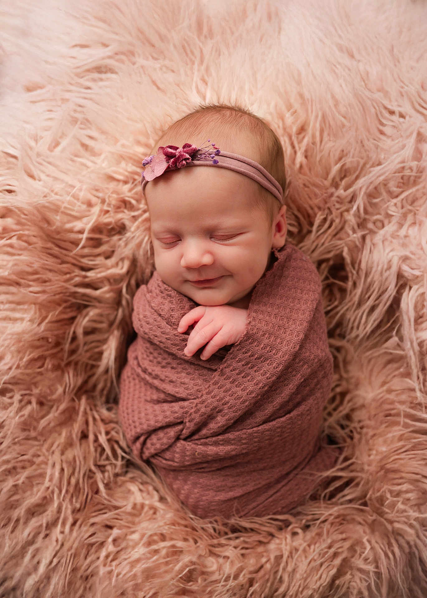 Louanne joined the competition — help win amazing prizes! baby, newborn, infant, swaddled, wrapped, blanket, fur, headband, smile, peaceful, portrait, studio, soft_texture, cozy, pink, rose, face, hand, eyes_closed, skin